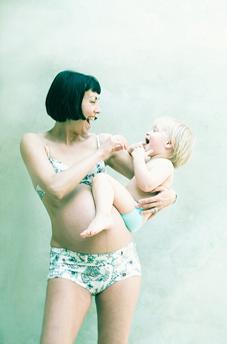 Schwangere Frau spielt mit ihrer Tochter