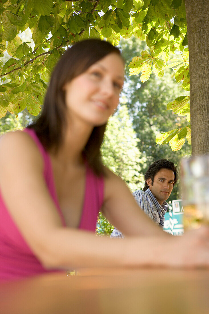 Flirt in Biergarten, Junge Frau und Mann beim Flirten in Biergarten, Starnberger See, Bayern, Deutschland