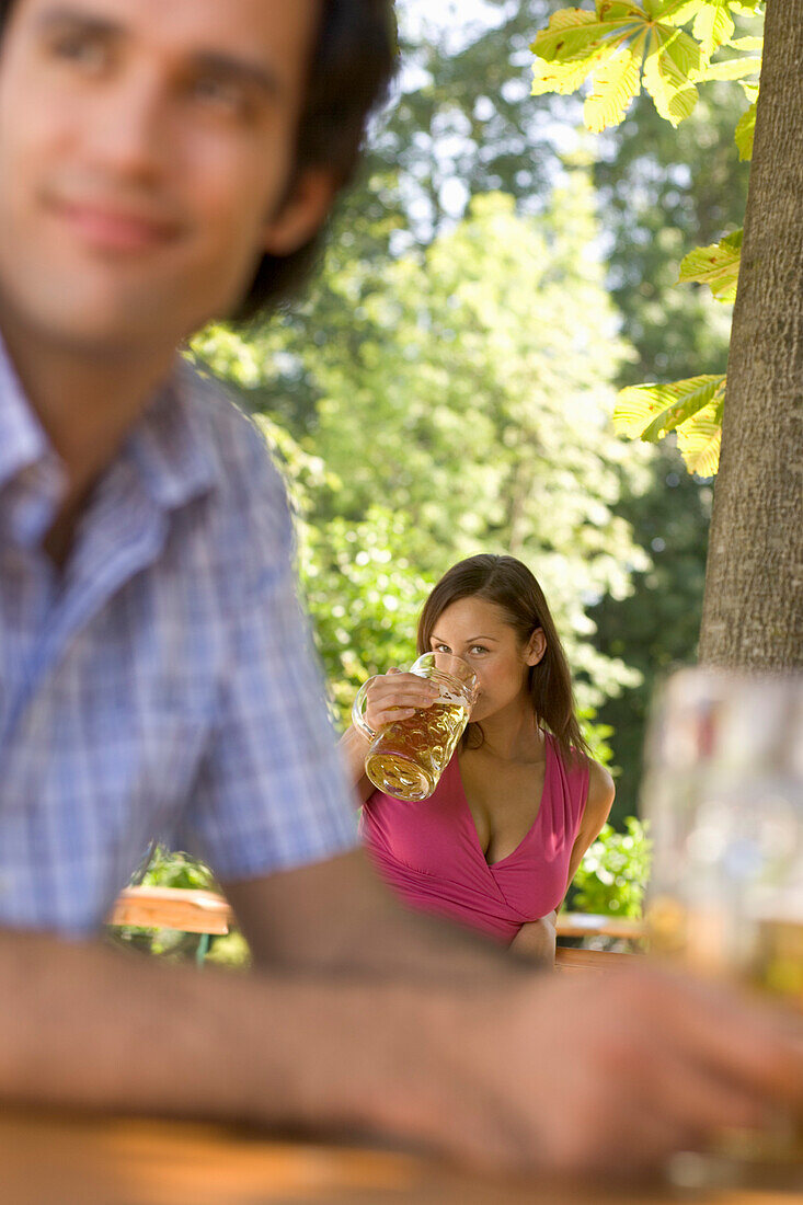 Flirt in Biergarten, Junge Frau und Mann beim Flirten in Biergarten, Starnberger See, Bayern, Deutschland