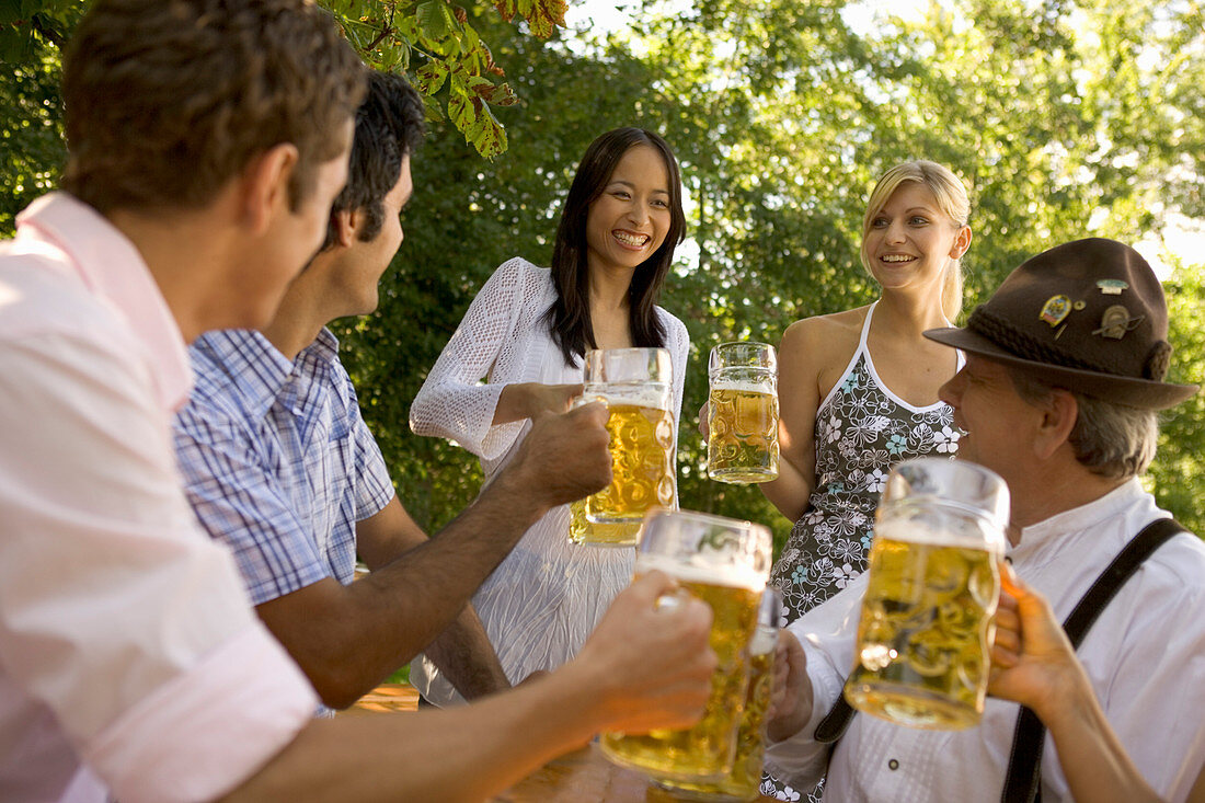 People with beer steins in beer garden, Munich, Bavaria