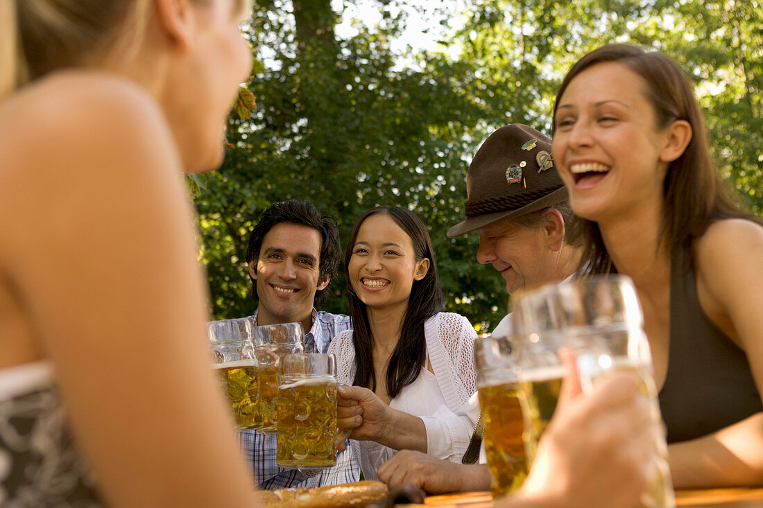 Friends in a beer garden, clinking glasses, Lake Starnberger, Bavaria, Germany
