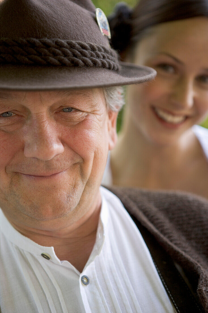 Mature man with young woman in background in beergarden, Bavaria, Germany