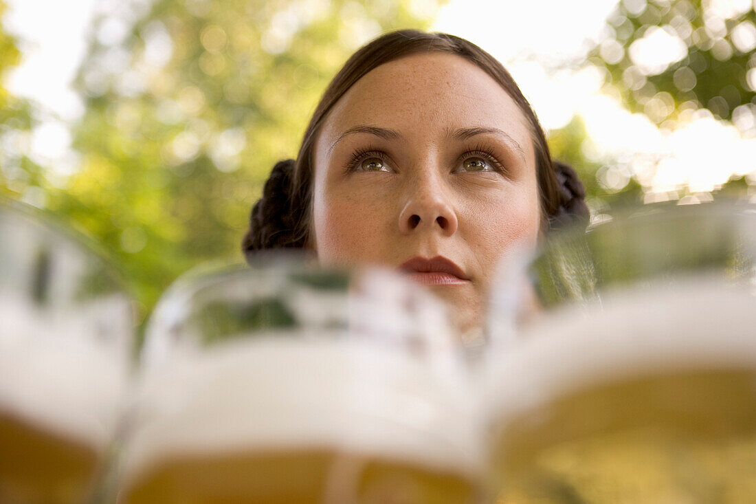 Waitress with beer steins in beer garden, Munich, Bavaria