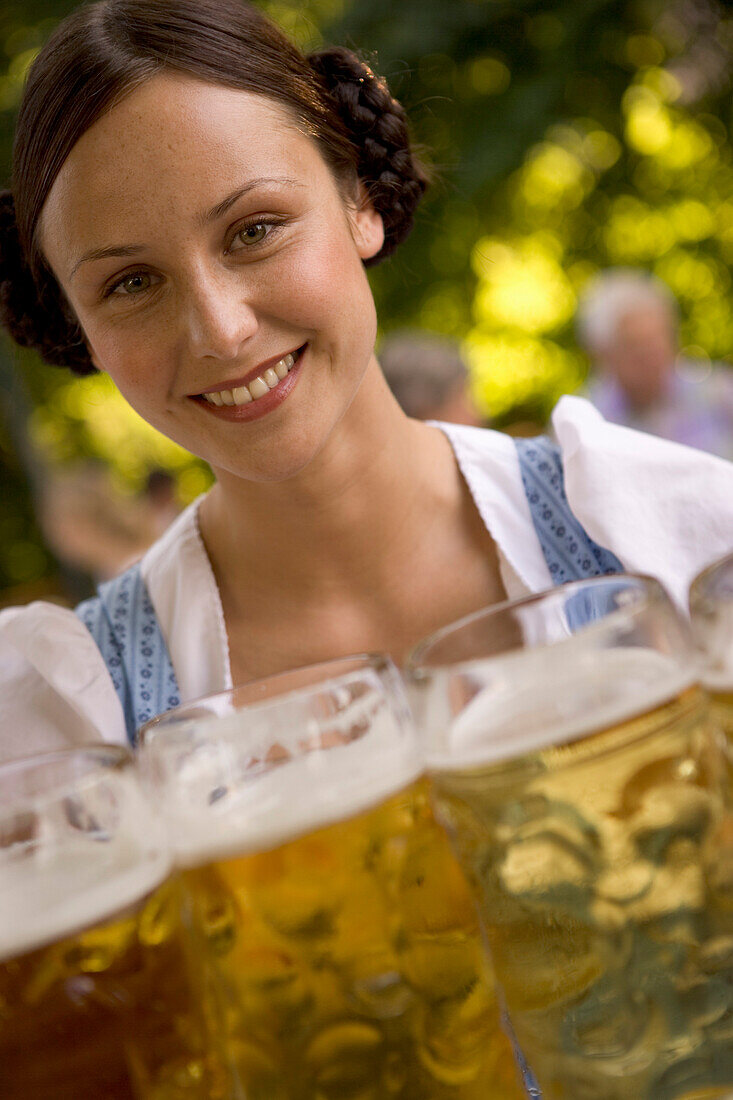 Young woman, waitress, carrying beer glasses, beer steins, Lake Starnberg, Bavaria, Germany