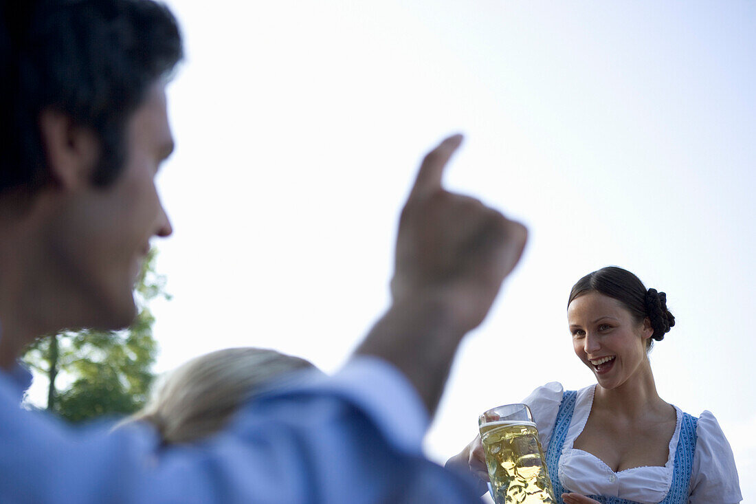 Mann bestellt ein Bier im Biergarten, Starnberger See, Bayern, Deutschland