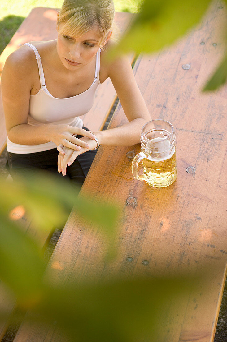 Junge Frau wartet auf jemand in Biergarten, Bayern, Deutschland