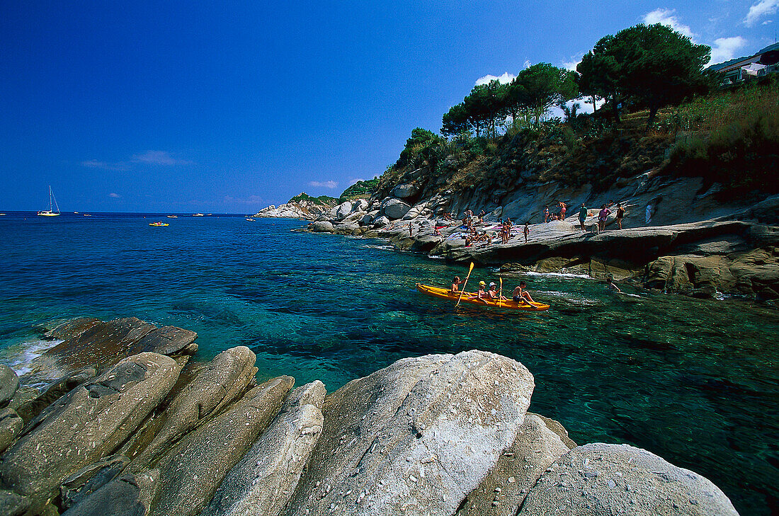 Menschen in einem Boot und an einem steinigem Strand, San Andrea, Elba, Toskana, Italien, Europa