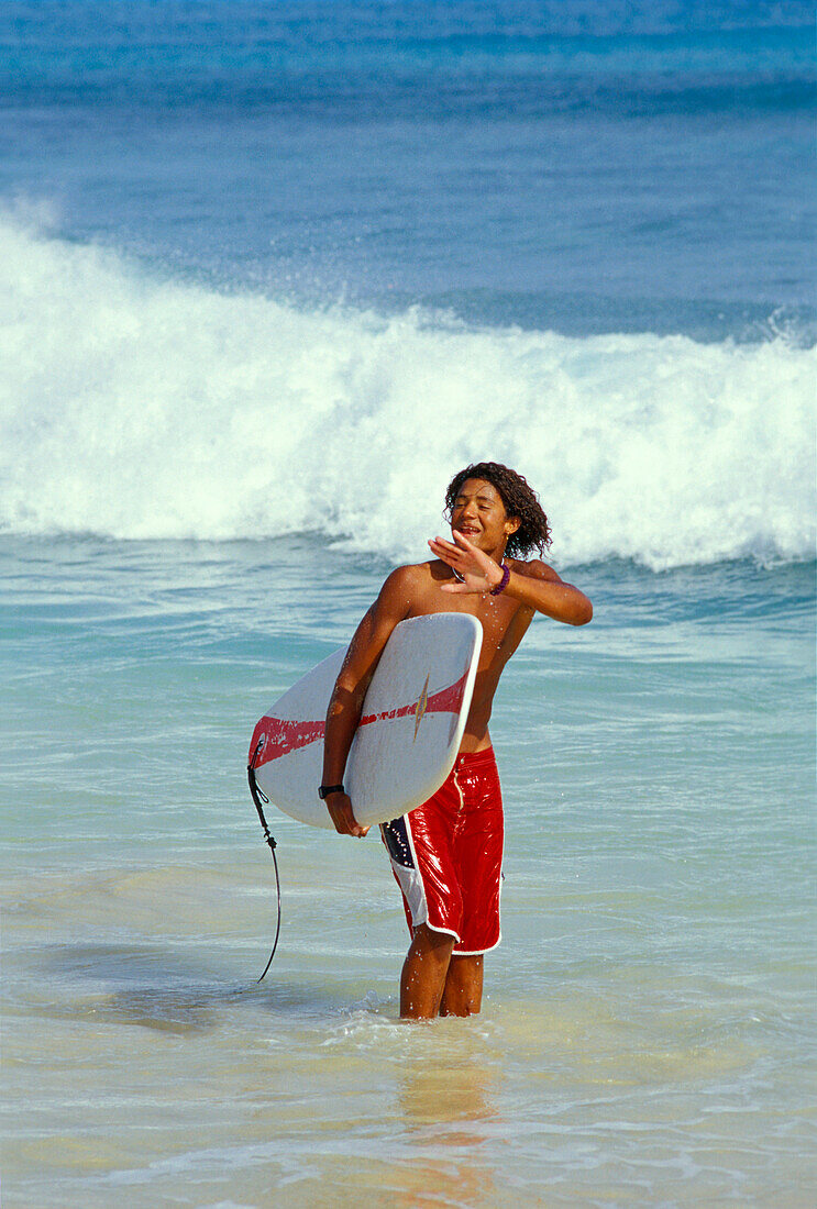 Young man with surfboard, Beach of Santa Maria, Sal, Cape Verde Islands, Africa