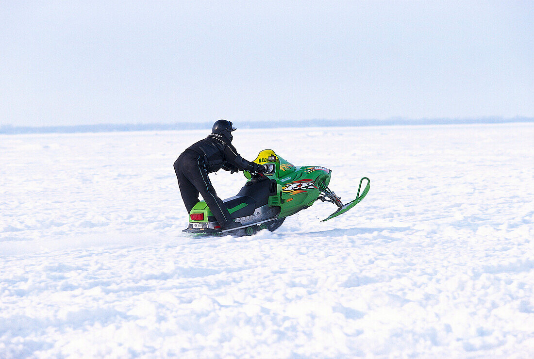 Man with snowmobile, St. Lawrence River, Quebec, Canada