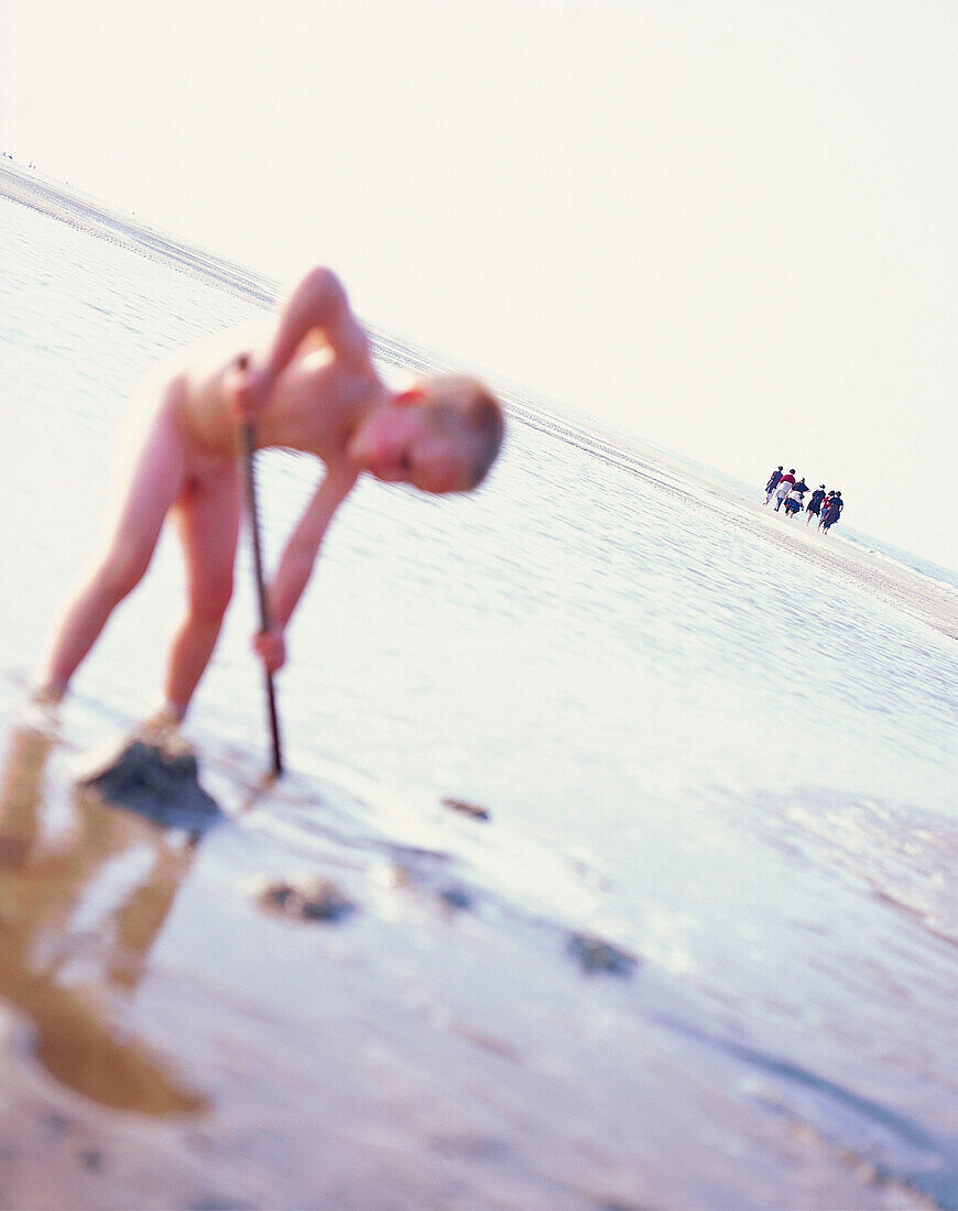 Junge beim Schaufeln am Nordseestrand, Nationalpark Wattenmeer, Insel Spiekeroog, Niedersachsen, Deutschland