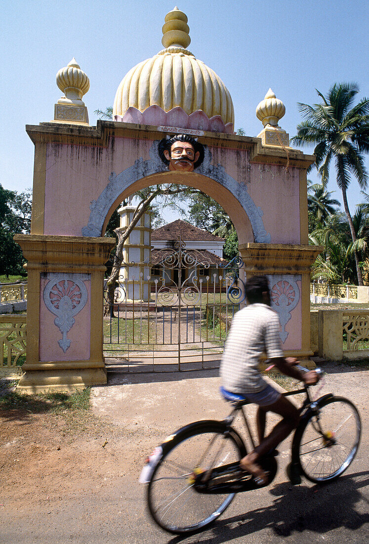 Radfahrer fährt vor einem Hindutempel, Margao, Goa, Indien