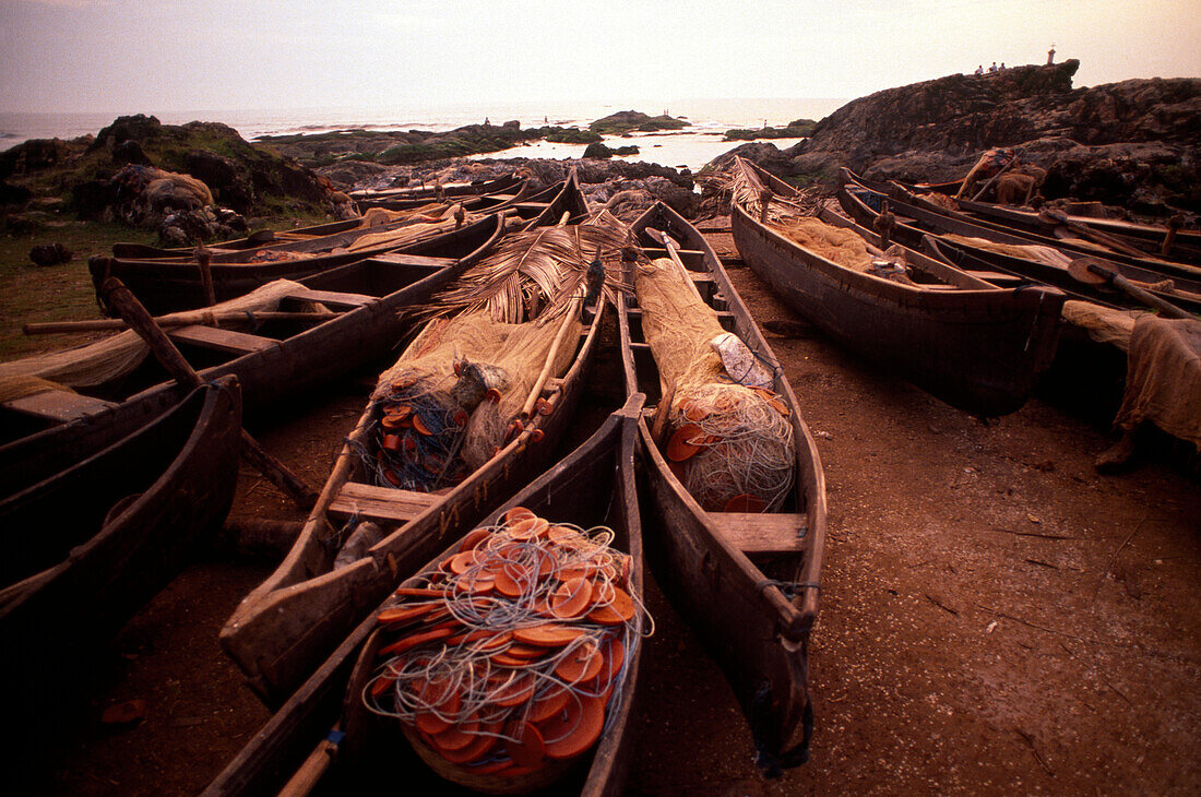 Fishing boats lying aon the beach at dusk, Anjuna Beach, Goa, India