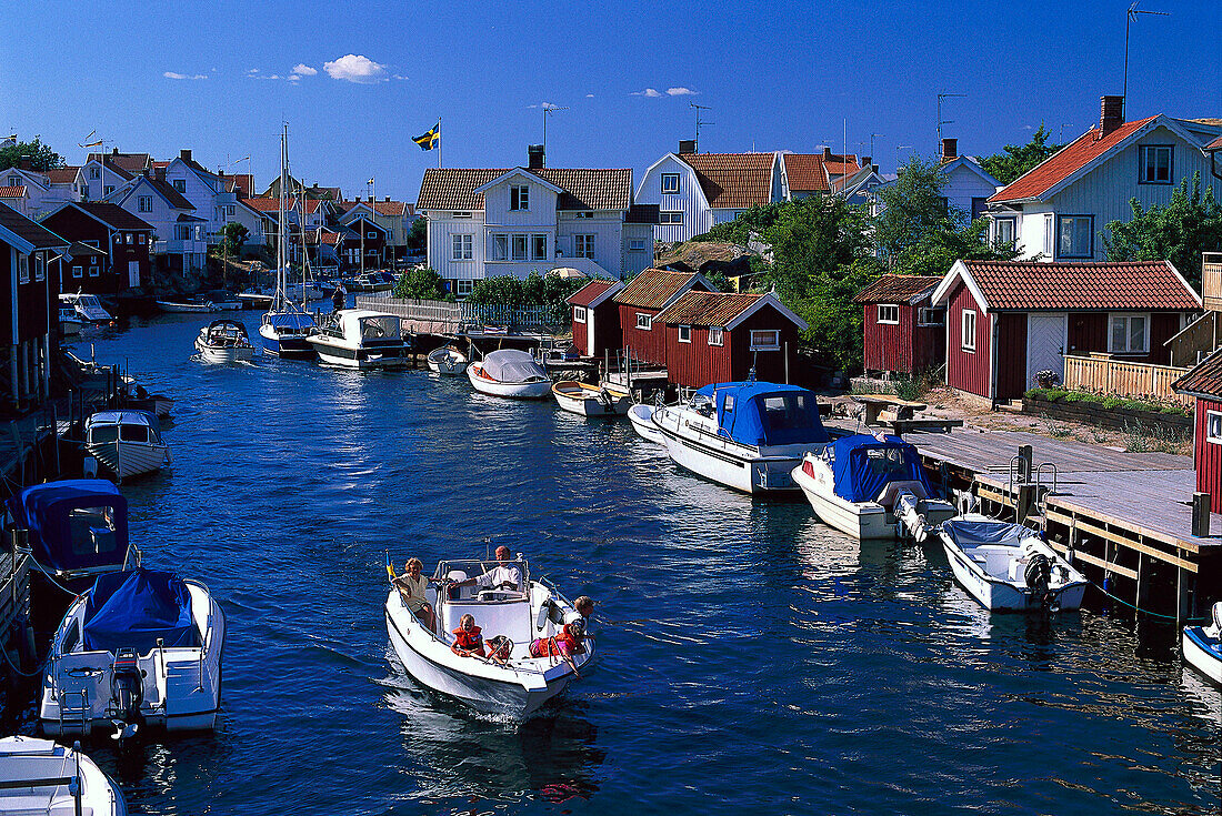 Sund Bohuslän mit Booten in einem Dorf unter blauem Himmel, Schweden, Europa