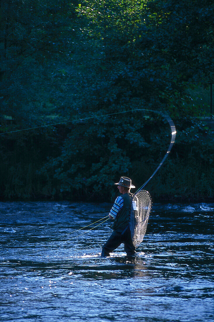 Ein Mann mit Angel steht im Fluß Mörrumsan Blekinge, Schweden, Europa