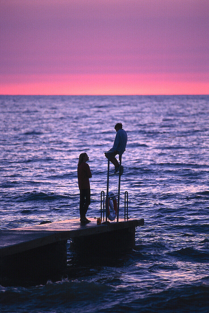 Two teenager talking on jetty, Havsbad, Baltic Sea. Visby, Gotland, Sweden