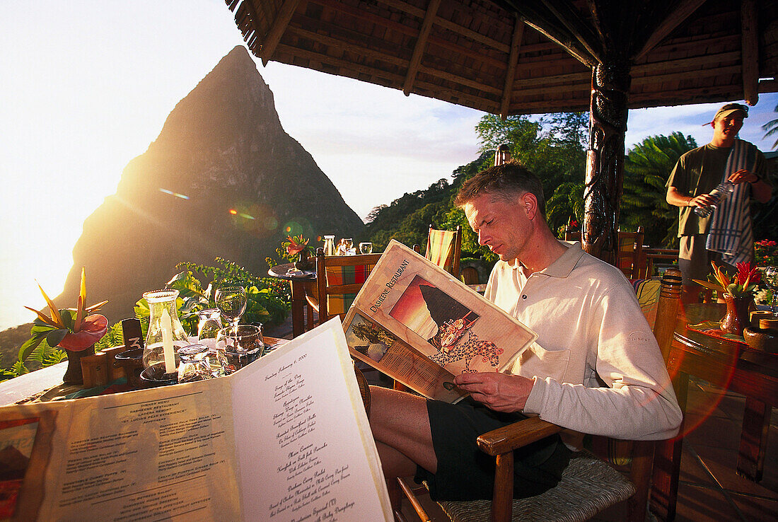 Tourist reading the menu at restaurant Dasheene at Ladera Resort, St. Lucia, Caribbean, America