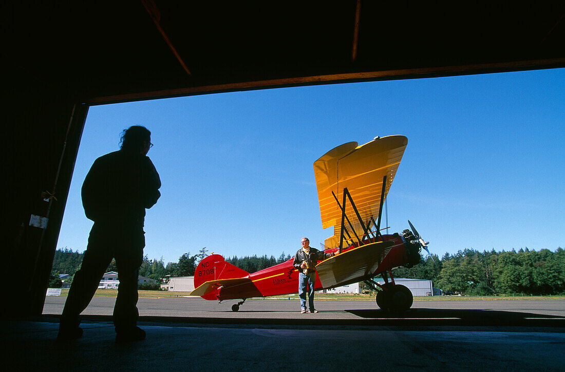Blick aus einem Hangar auf ein Flugzeug unter blauem Himmel, Washington, USA