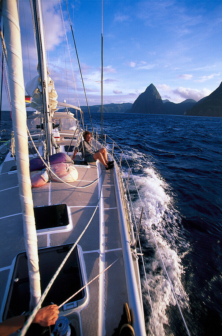 Sailing boat off Deux Pitons island under clouded sky, St. Vincent, Grenadines, Caribbean, America