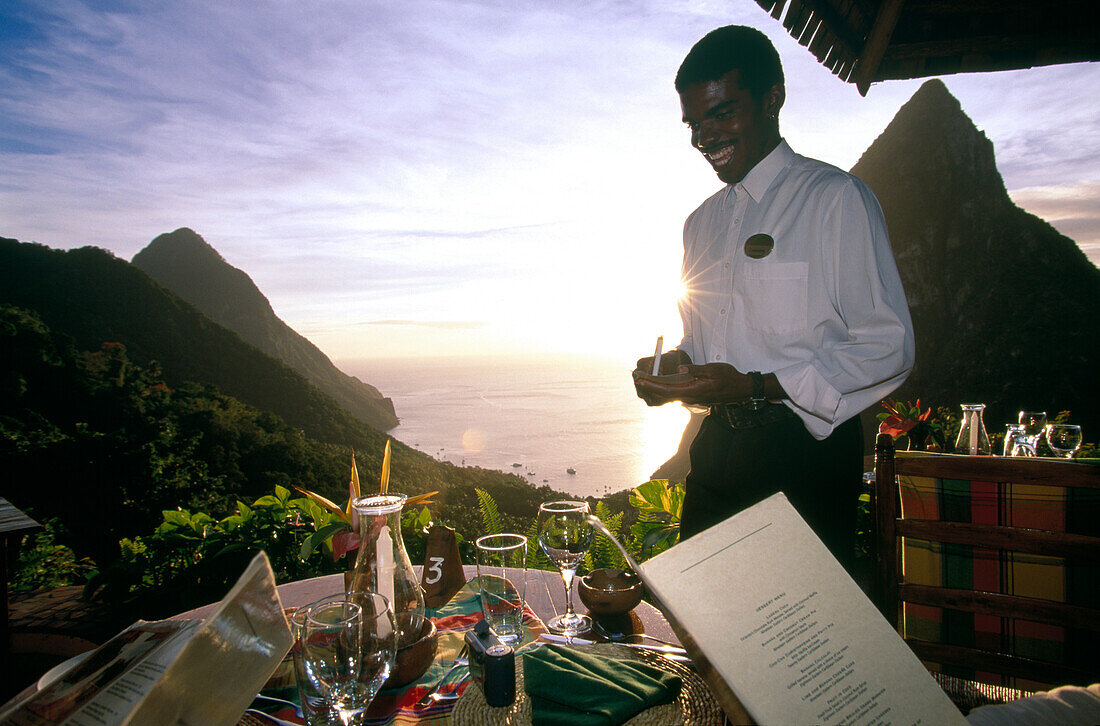 Lachender Kellner steht auf der Terrasse des Restaurant Dasheene, Ladera Resort, Soufrière, St. Lucia, Karibik