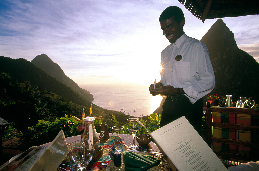 Laughing waiter standing on the terrace of Restaurant Dasheene, Ladera Resort, Soufrière, St. Lucia, Carribean