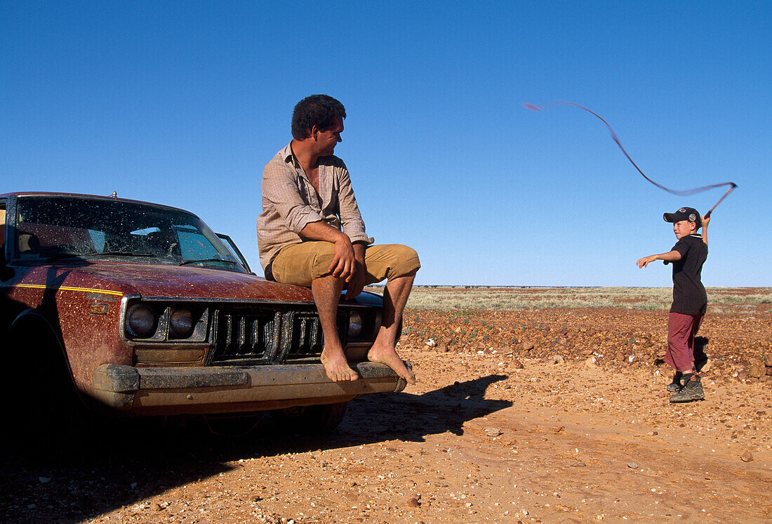 Wartender Mann mit Kind nach Autopanne im Simpson Desert, Queensland, Australien