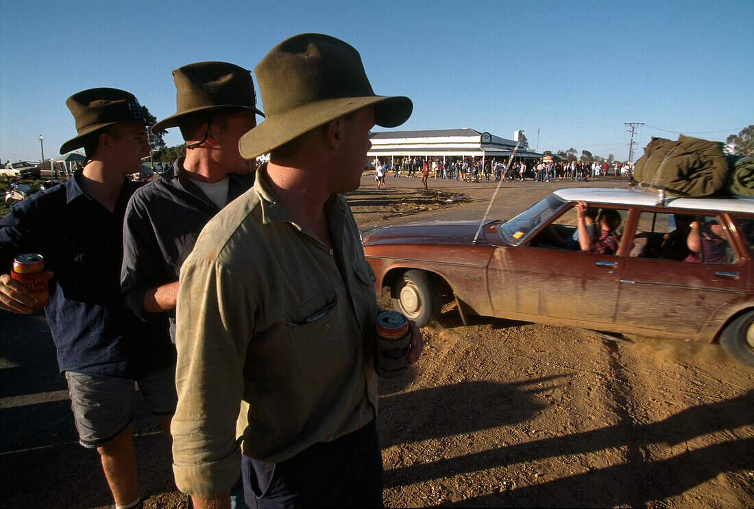 Young men looking at a car, a crowd in front of the pub, Birdsville, Simpson Desert, Queensland, Australia