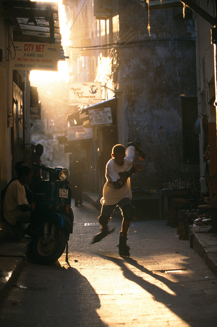 Ein Junge mit Inline Skates in einer Gasse der Altstadt, Zansibar Town, Sansibar, Tansania, Afrika