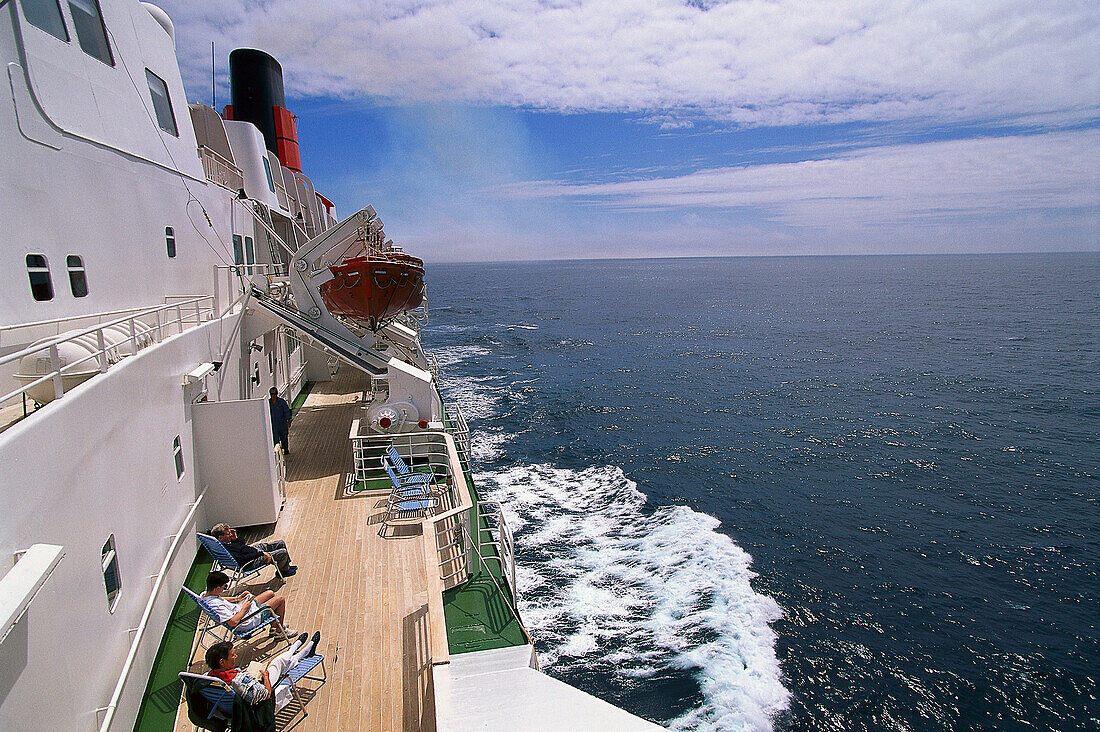 People sunbathing on a deck of cruise ship Queen Elizabeth 2