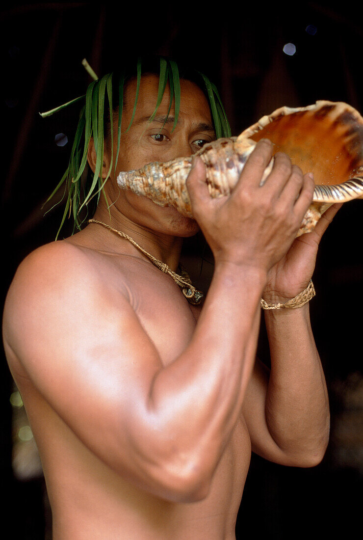 Eingeborener bläst in Muschel, Tiki Theatre Village, Moorea, Polynesien