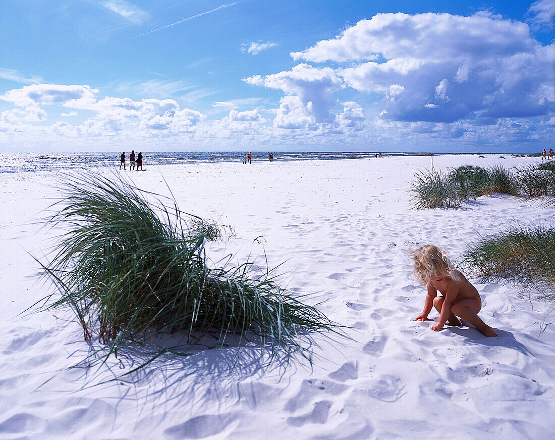 Child playing on the beach in the sunlight, Dueodde, Bornholm, Denmark, Europe