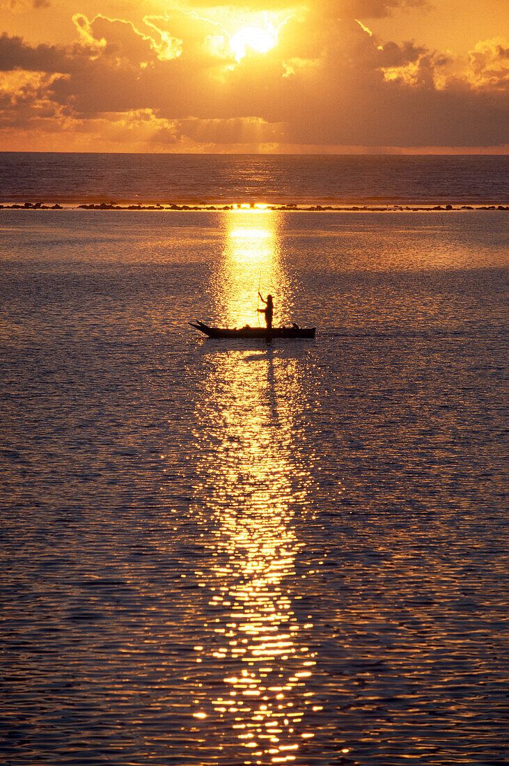 Fischer und Fischerboot bei Sonnenaufgang auf dem Meer, Sansibar, Tansania, Afrika