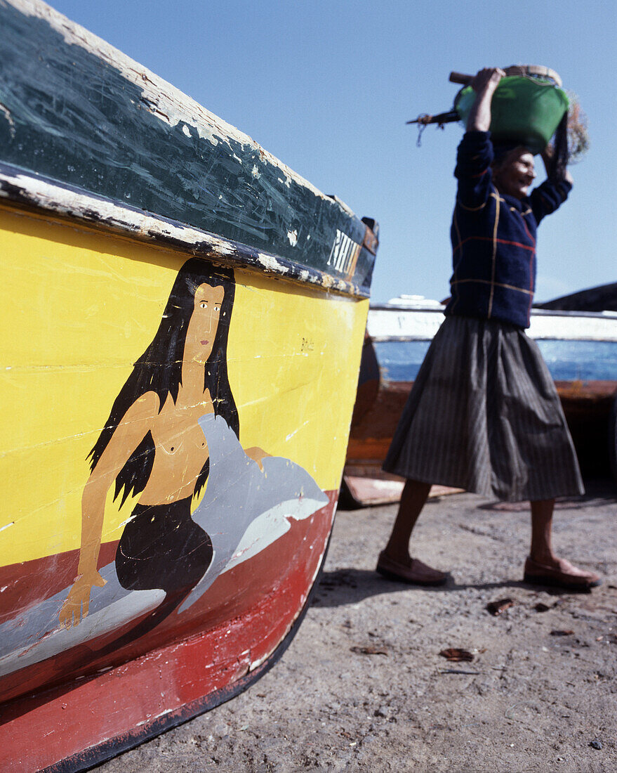 Local woman carrying fish in a basket, Fishing boat with painting of a mermaid, Ponta do Sol, Santo Antao, Cape Verde
