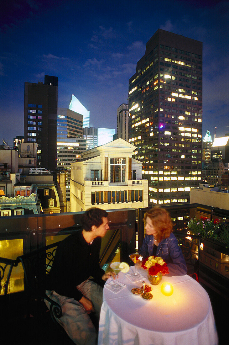 A couple at a roof terrace in the evening, PenTop Bar, Peninsula Hotel, New York, USA, America