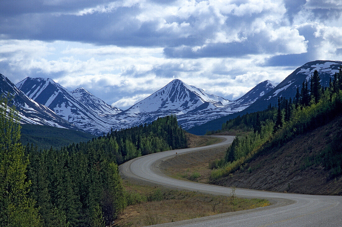 Alaska Highway in front of snow covered mountains, Yukon Territory, Canada, America