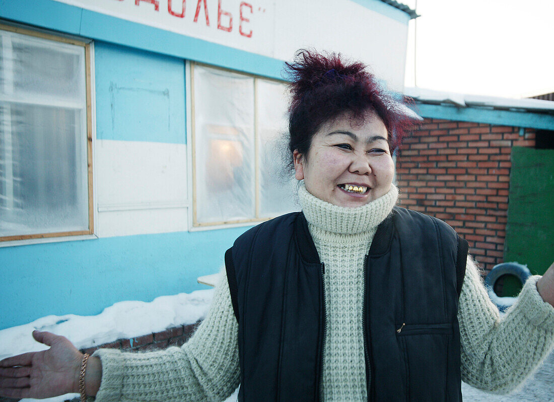 Lächelnde Frau steht vor einem Haus, Omsk, Sibirien
