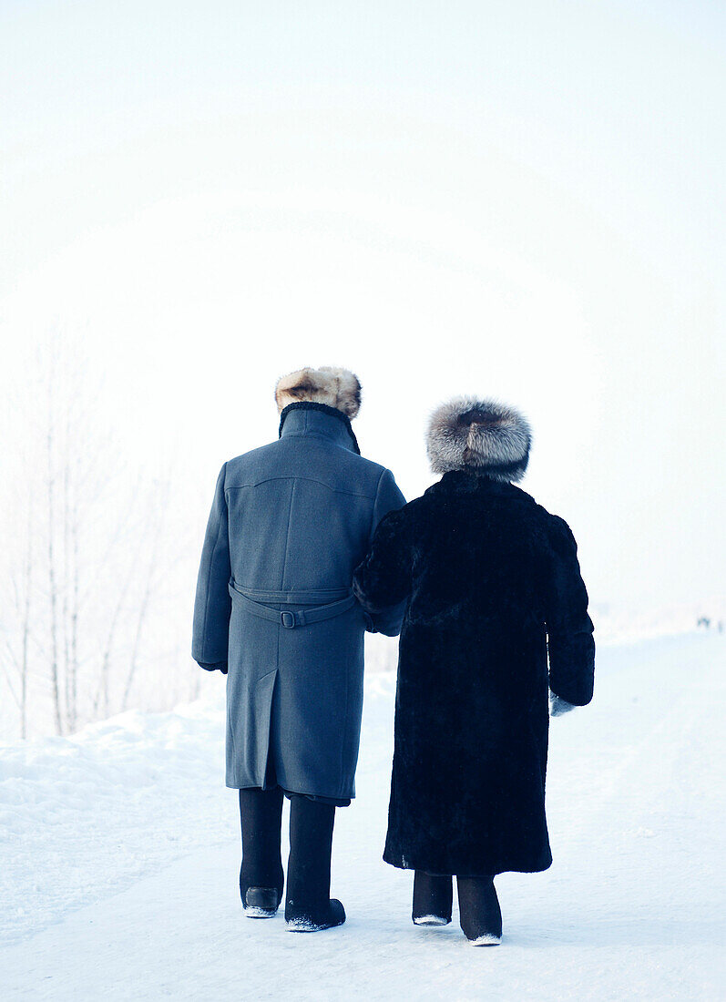 Ein Paar geht auf einem verschneiten Weg spazieren, Omsk, Sibirien