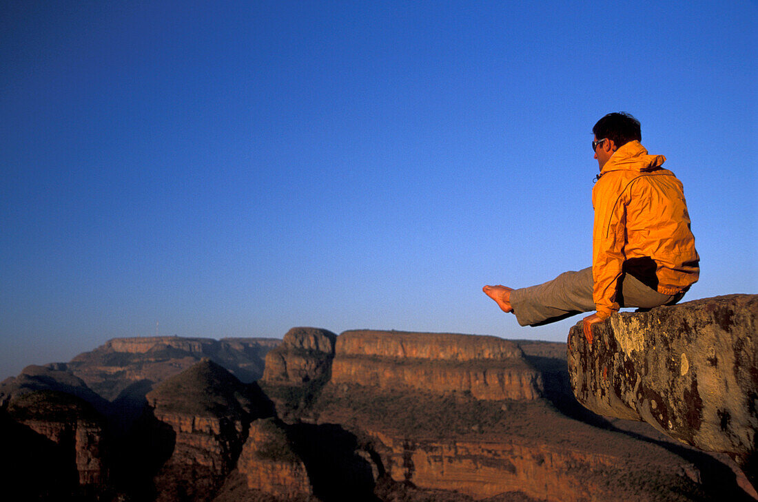 Mann im Winkelstütz auf einem Felsen, Three Rondavels, Blyde River Canyon, Südafrika