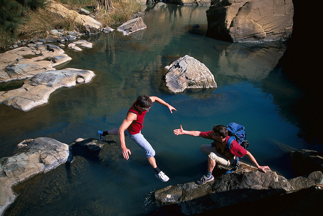 Two people crossing a river, Helping Hand, South Africa