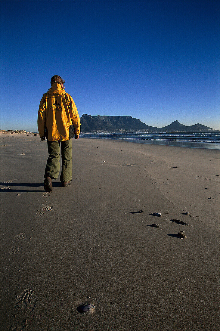 Woman walking on beach, Cape Town, South Africa