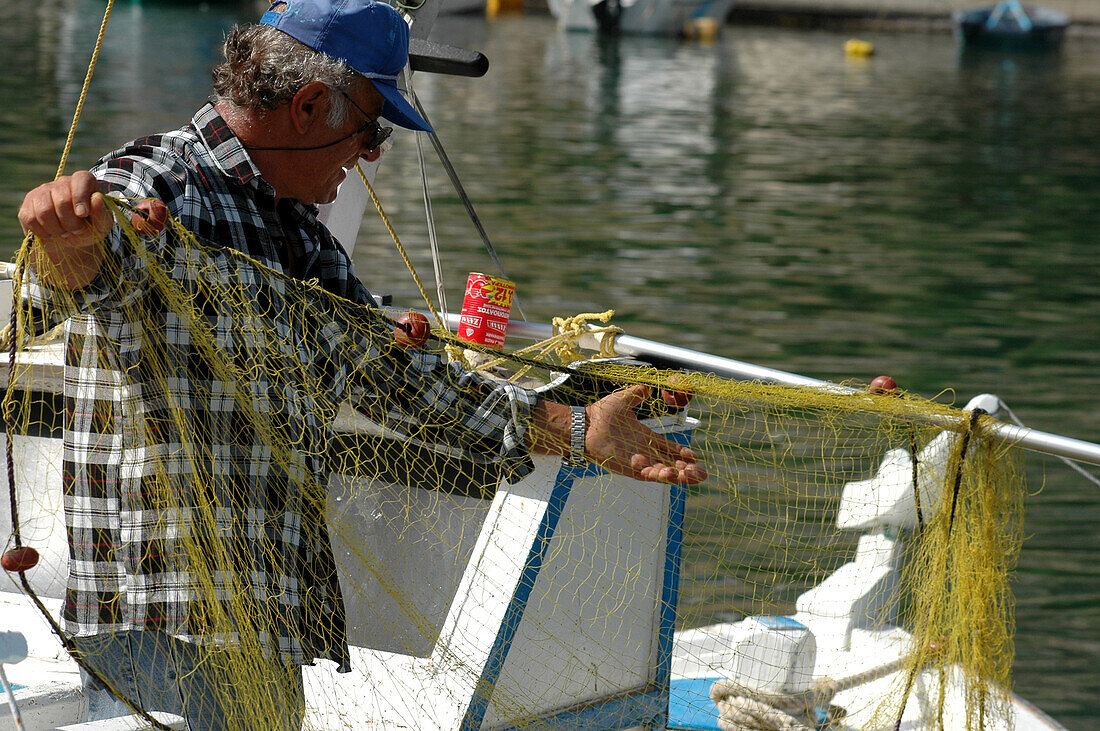 Fisherman recovering his net, Port of Vathi, Kalymnos, Greece