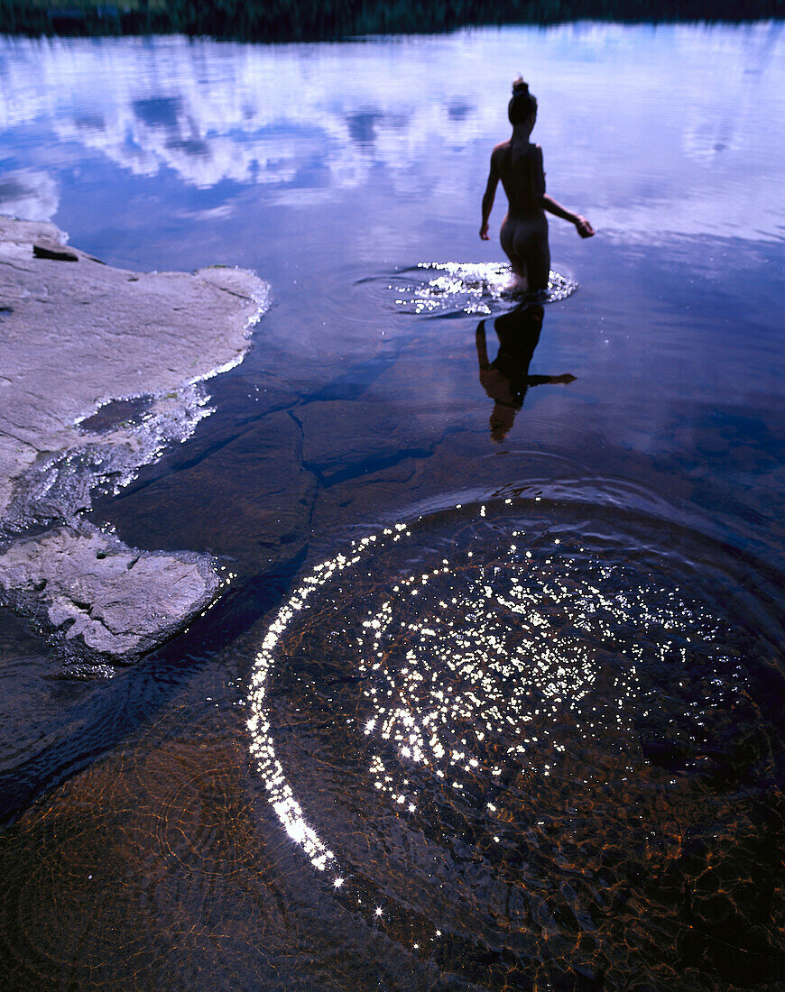 Naked woman standing in a lake, Sweden