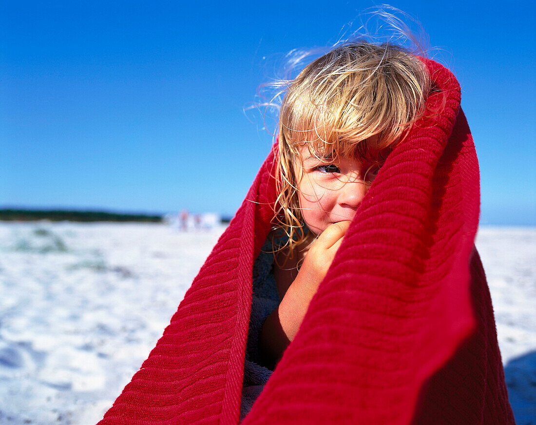Girl 2-3 Years, on beach wrapped in red towel, Dueodde, Bornholm, Baltic Sea, Denmark