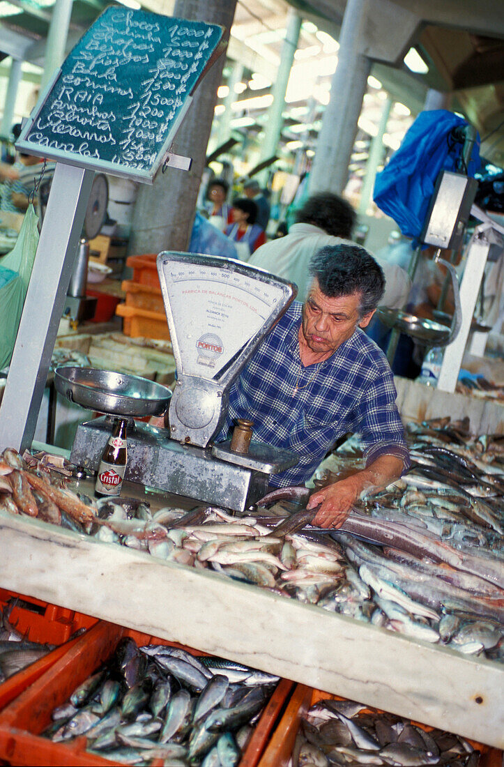 Vendor at a fish stand at the market hall, Loulé, Faro, Algarve, Portugal, Europe