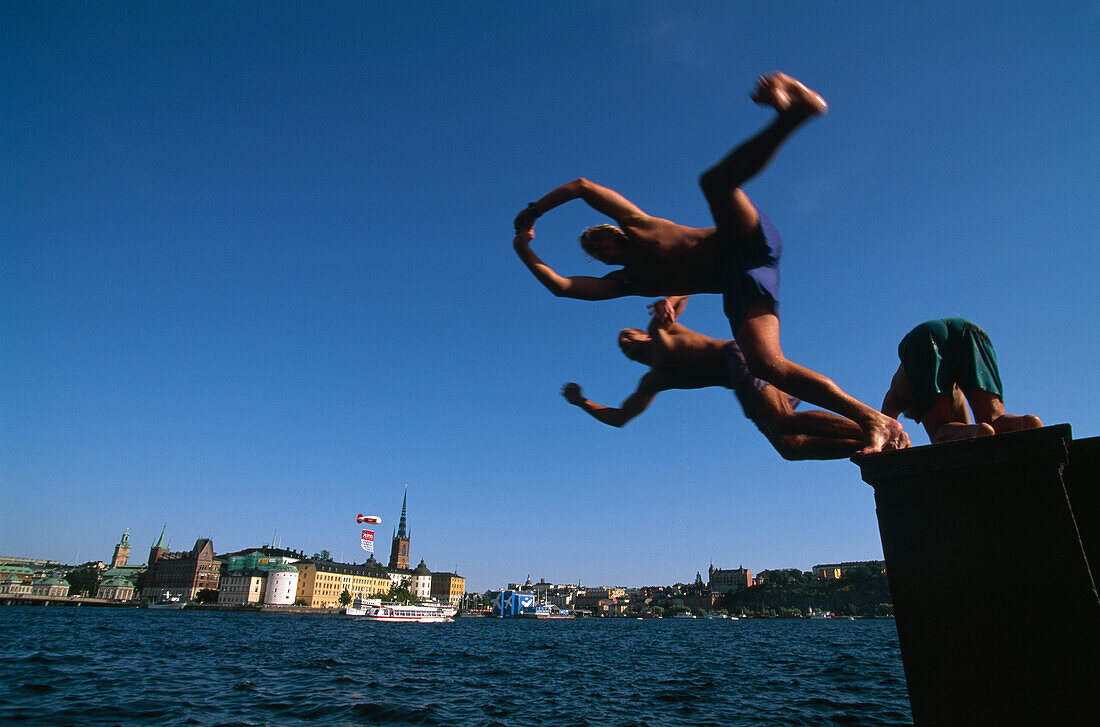People bathing at Stockholm City Hall, Stadshuset, in front of Riddarholmen Island, Stockholm, Sweden