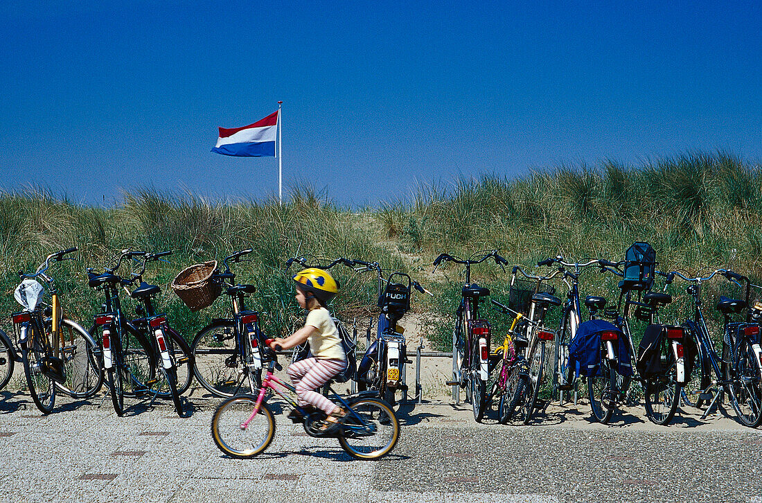 Mädchen fährt Fahrrad, Fahrräder am Strand, Katwijk aan Zee, Niederlande