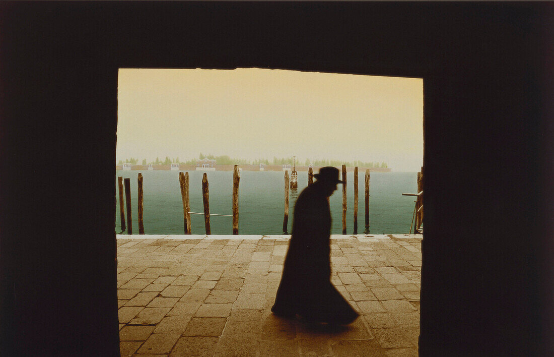 Priest takes a walk at San Michele in Venice, Italy