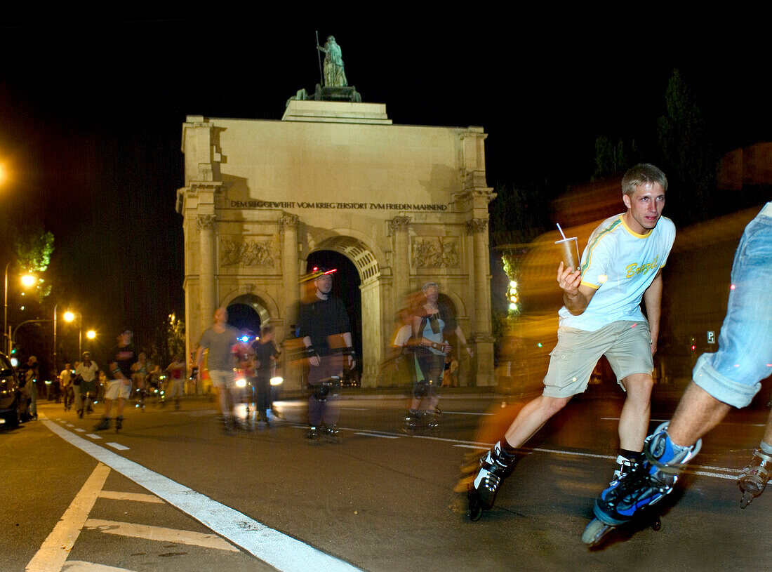 Menschen auf Inline Skates vor dem Siegestor bei Nacht, Ludwigstrasse, München, Bayern, Deutschland, Europa