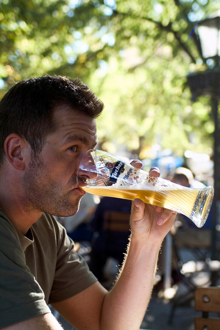Man drinking Weissbier in Beergarden Hofgarten, Munich, Bavaria, Germany