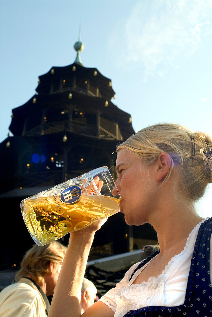 Girl in Dirndl dress drinking beer in beergarden, Chinesischer Turm, English Garden, Munich, Bavaria, Germany