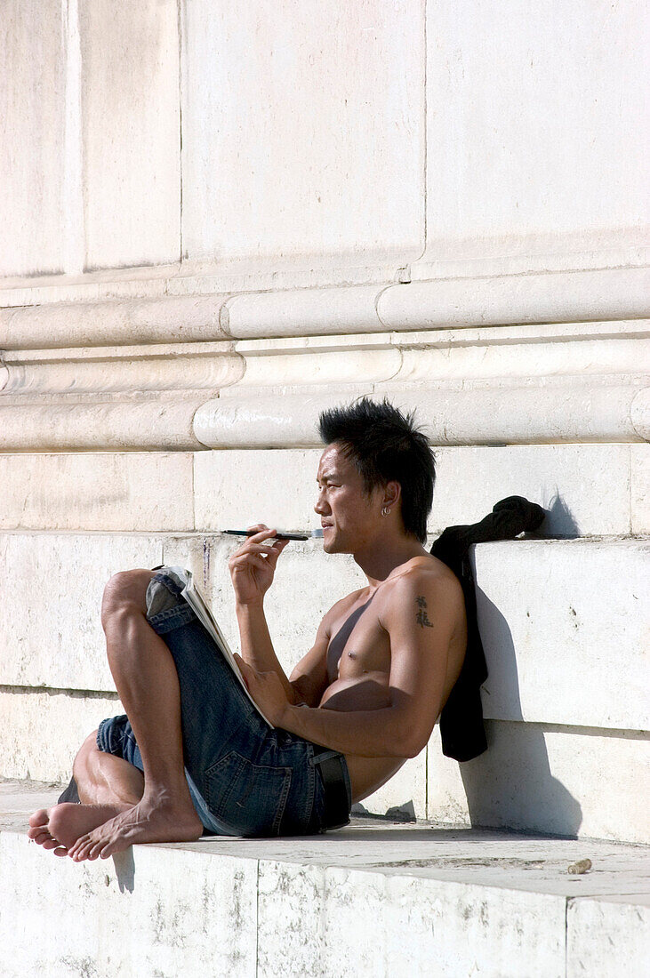 Young man sunbathing at Koenigsplatz, Munich, Bavaria, Germany